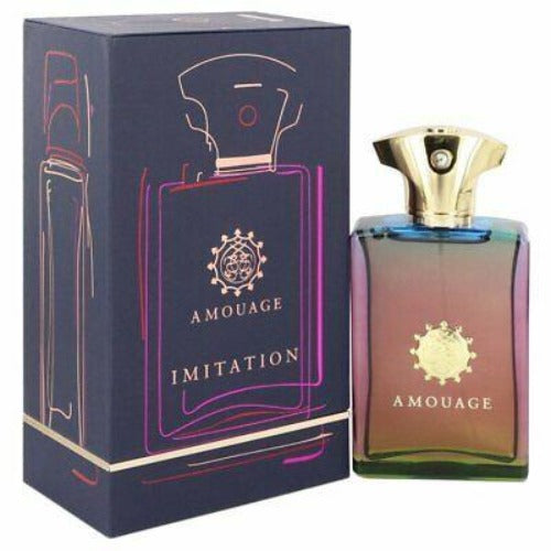 Amouage Imitation Man fragrance bottle with gradient pink and blue liquid next to dark navy box packaging with gold accents.