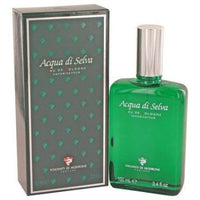 Acqua di Selva cologne bottle and box. Green glass spray bottle next to dark green packaging with teal leaf pattern.