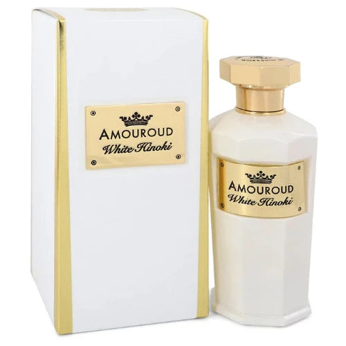 Amouroud White Hinoki perfume bottle with gold cap next to white and gold branded box